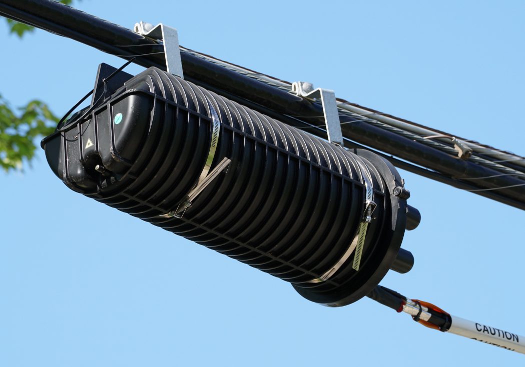 Aerial fiber splice closure mounted on the strand